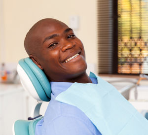 man smiling at dentist office after prompt emergency dentistry services at Alamo Ranch Dental