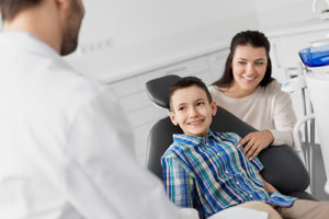 young boy and mom meeting dentist for child dentistry services